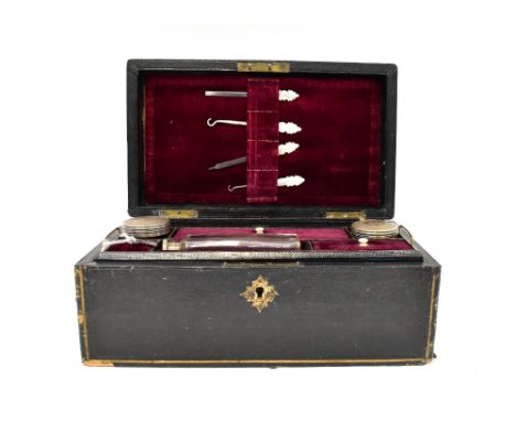 A late 19th/early 20th century ladies' travelling vanity and jewellery box, the black covered box revealing manicure tools to