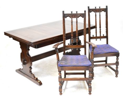 A Priory-style dining room suite comprising an oak draw-leaf table, six spindle back chairs (4+2), a dresser with boarded she