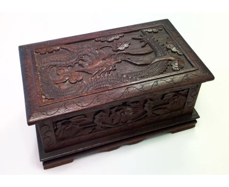 An early/mid-20th century Chinese carved wooden casket, the lid decorated with a dragon, width 31cm. CONDITION REPORT Overall