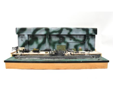 A scratch-built model scene depicting a moored German submarine by the dockside, with train, wagons, soldiers, etc, on a heav