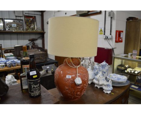 A large pottery table lamp decorated with flowers 