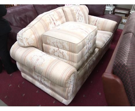 A cream patterned 2 seater sofa and pouffe