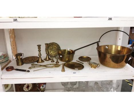 A shelf of brassware including Victorian jam pan, saucepan & miners lamps etc.
