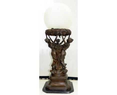 AN ART NOUVEAU STYLE FIGURAL LAMP OF NYMPHS HOLDING A FROSTED GLASS GLOBE SHADE, 88CM H