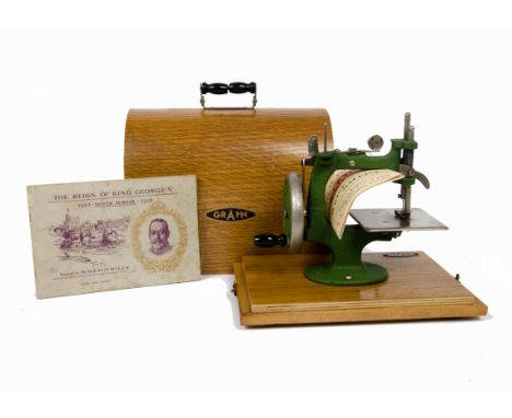 A wooden cased child's Grain manual sewing machine, green cast iron G frame on wooden base. Together with a Wills cigarette c