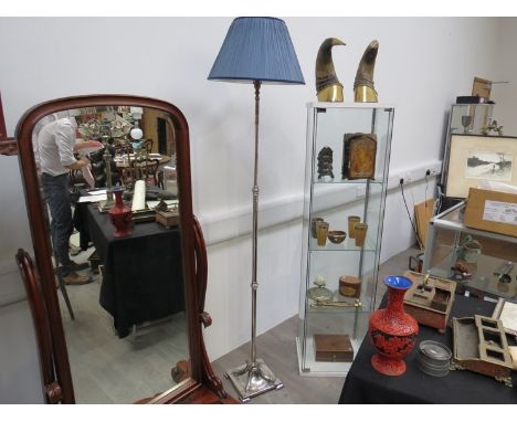 An EPNS height adjustable standard lamp with shade, on mythical sea creature and decorative spade feet 