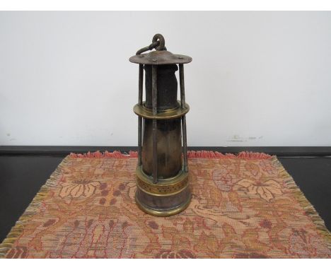 A brass and steel miners lamp with tall conical glass and short gauze
