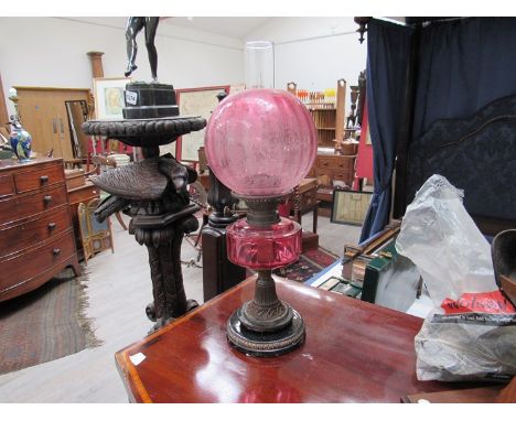 A Victorian cranberry glass oil lamp with globular shade 