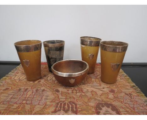 Four Victorian horn beakers with silver rims, all cracked and a silver rimmed bowl 
