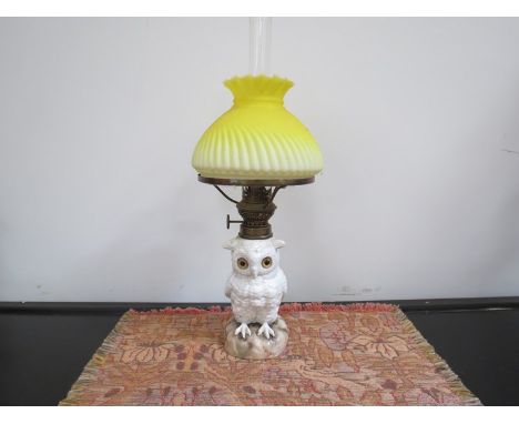 An early 20th Century ceramic owl oil lamp with yellow wrythen form shade 41cm tall 