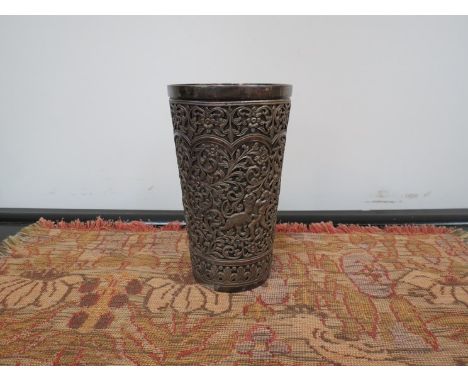 An Iranian silver beaker with pierced decoration of elephants and hunters, 14cm tall