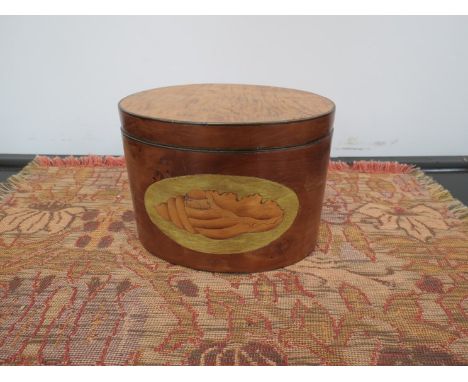 A 19th Century yew wood veneered oval tea caddy with inlaid shell design 