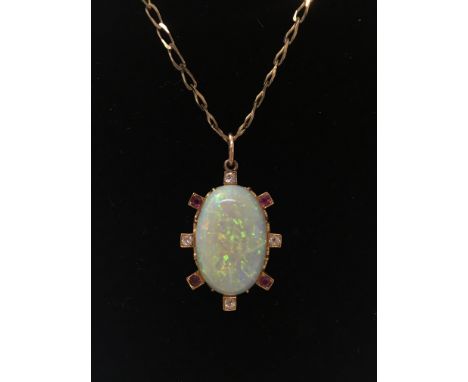 A 9ct gold chain with attached opal pendant, surrounded by four white diamonds and four rubies, the opal measuring approximat