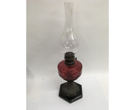 A Victorian oil lamp with cranberry glass well