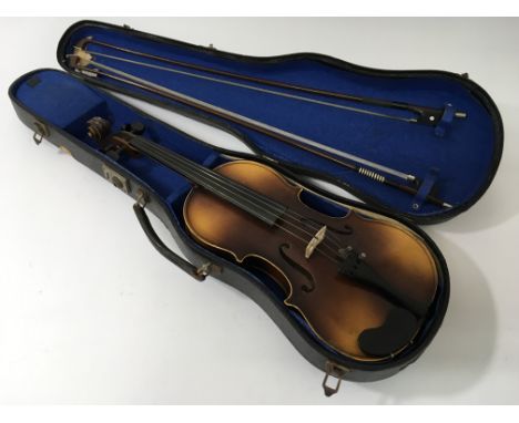 A cased vintage Antonius Stradivarius Cremonensis violin with two bows.