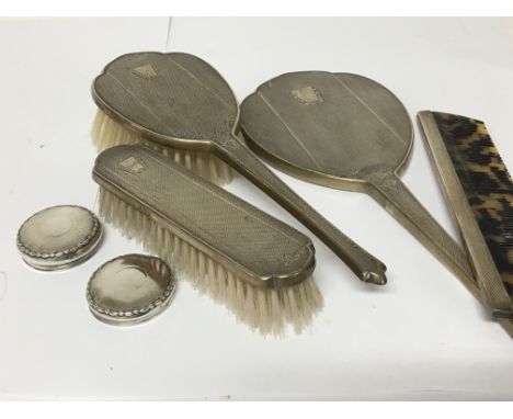 A Silver dressing table set comprising a mirror comb, brushes and two silver lids.