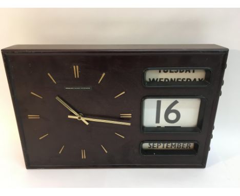 A retro English Clock Systems wall clock with calendar.Approximately 29x45cm
