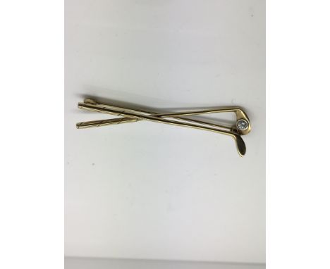 A 9ct gold and single diamond set stick pin, formed as entwined golf clubs, in leather case