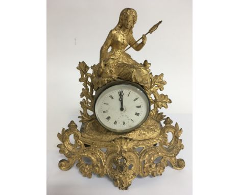A gilt ormolu clock with barrel mechanism and female figure on top. With key. Height approx 31cm
