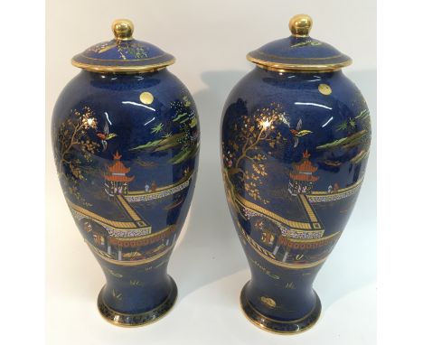 A pair of Carltonware powder blue lidded vases decorated in the Japanese style with river scene and pagodas.Approximately 29c