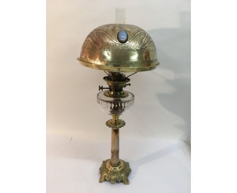 An Arts and Crafts oil lamp with milk glass lozenge decoration to the shade, approx 72.5cm.