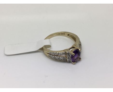 An oval amethyst set with diamonds set in two colours of gold. Weight approx 3.04g Size approx O