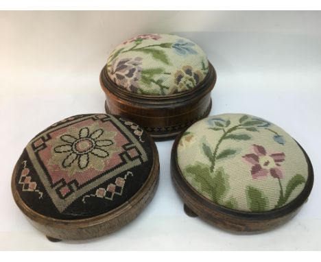 Three Victorian walnut stools with tapestry seats.