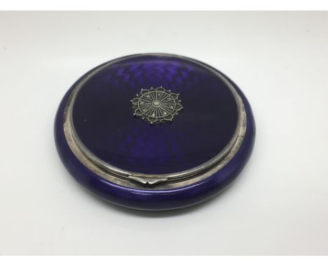 A silver and purple enamel compact.