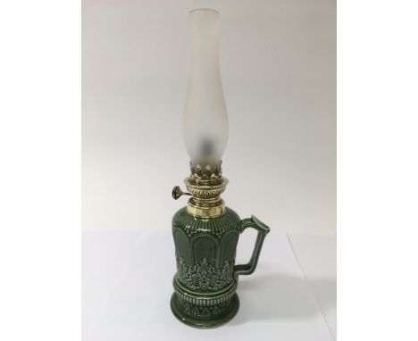 A green glazed ceramic oil lamp, approx 37.5cm.