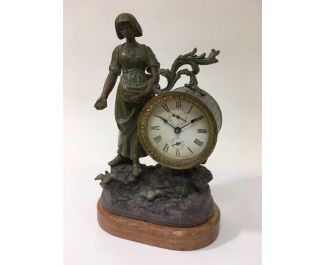 A spelter figural clock of a woman feeding birds, the clock with two subsidiary dials, approx 33.5cm.
