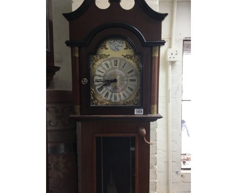 A reproduction mahogany ecs Westminster chiming German clock with three visible weights and a pendulum,
