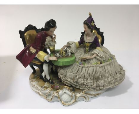 A capodamonte porcelain figure of a regency couple playing chess.