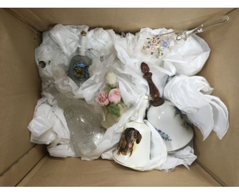 A box of mixed glass together with a collection of ceramic bells.