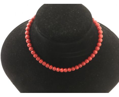 A vintage red bead choker necklace possibly red coral