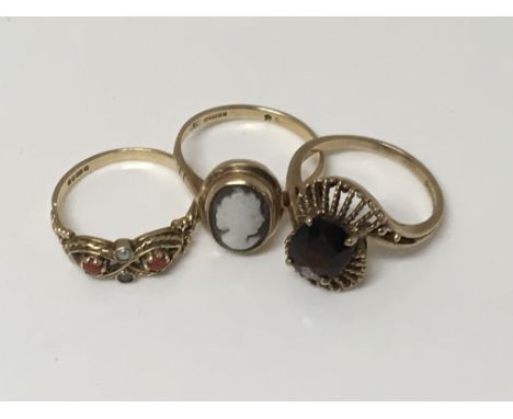 Three 9ct gold rings comprising a small Cameo ring, a coral ring, and one other set with a Garnet (3)