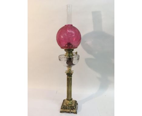 A brass oil lamp with crackleware cranberry glass shade, approx height 70.5cm.