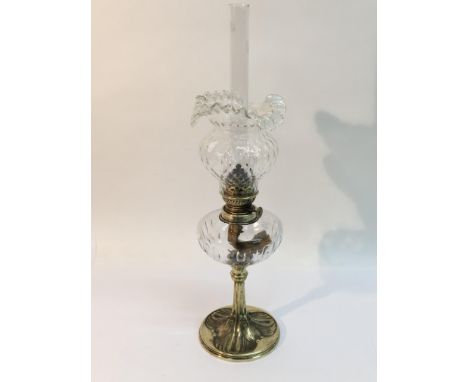 A brass oil lamp with clear glass shade, the base decorated with owls, approx 54cm.