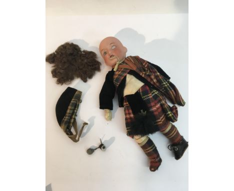 A German Armand Marseille bisque headed doll in traditional Scottish dress.Approximately 21cm high.Lacking an eye and one sho