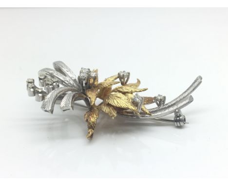 An 18ct yellow and white gold brooch with foliage influence decorated with 13 diamonds. Total weight approximately 14.1 grams