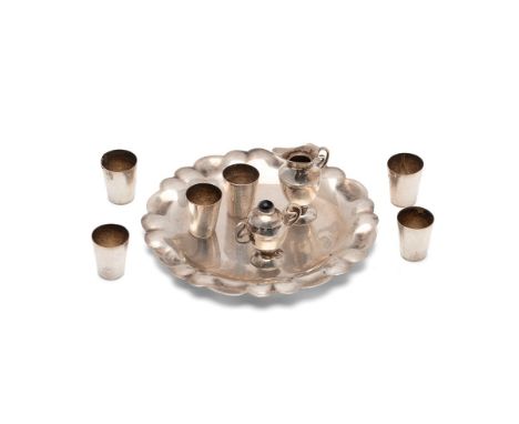 Miniature silver table service with a ewer and six beakers, with a lidded vessel on serving tray, indistinct marks, 8cm wide,