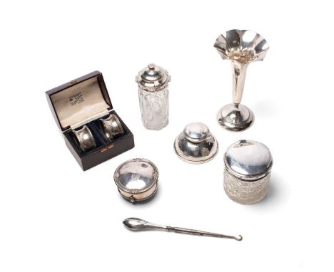 A collection of silver items to include cased silver napkin rings, silver topped cut glass jars, bud vase, inkwell three foot