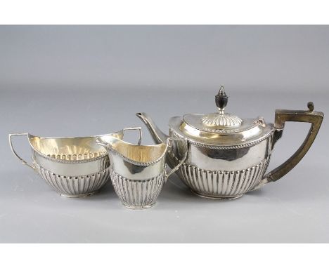 An Edwardian Silver Bachelor Tea Trio. The trio comprising tea pot, milk jug and sugar bowl, London hallmark dated 1924/25, m