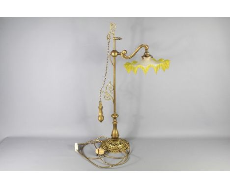 An Edwardian Brass Lamp Stand. The lamp stand fitted with a yellow-trimmed shade, approx 80 cms h.