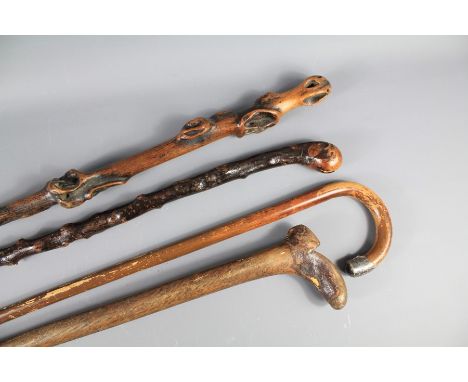 Vintage Walking Sticks. This lot includes a walking stick with a shoe-carved handle, two rough-hewn walking sticks and others