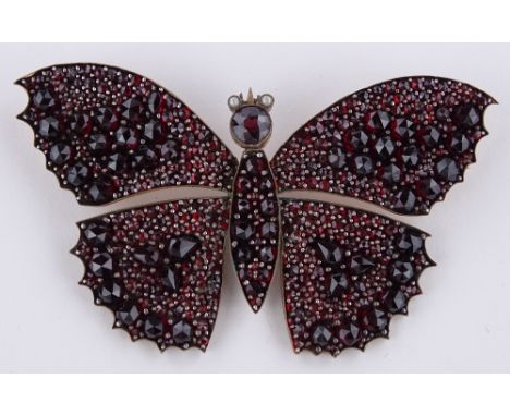 A large Victorian faceted garnet and seed pearl set butterfly brooch, unmarked gold settings, wingspan 78.6mm, 26.9g