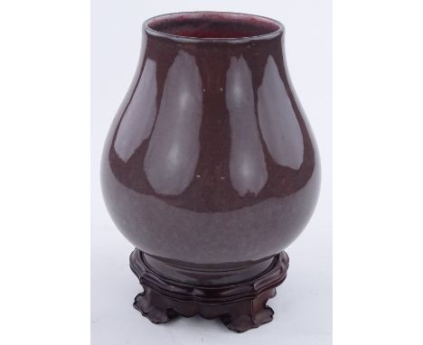 A Chinese brown glazed porcelain vase, seal mark under base, on carved hardwood stand, overall height 26cm