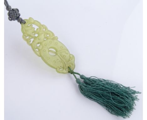 A Chinese carved and pierced jade pendant, length 7.5cm, with silk tassels on silk cord