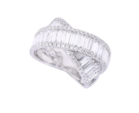 A DIAMOND CROSSOVER RING Featuring baguette and round brilliant cut diamonds totalling approximately 2.90 Cts, mounted in an 