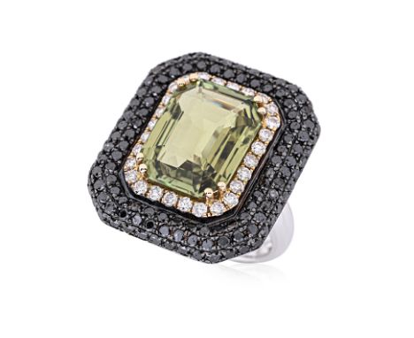 A CHRYSOBERYL, DIAMOND AND BLACK DIAMOND RING Featuring a yellowish green chrysoberyl weighing approximately 8.24 Cts, mounte