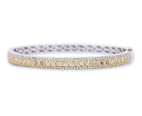 A YELLOW AND WHITE DIAMOND BANGLE Featuring cushion cut yellow diamonds totalling approximately 4.68 Cts (marked), mounted in
